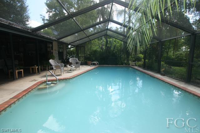 13901 Rod And Gun Club Road Fort Myers, FL 33913 - Photo 13 of 25 a view of pool with lawn chairs and iron fence