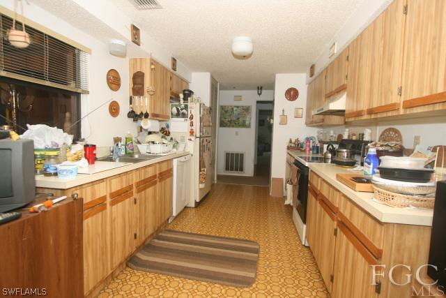 13901 Rod And Gun Club Road Fort Myers, FL 33913 - Photo 18 of 25 a kitchen with stainless steel appliances a sink and a refrigerator