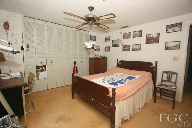 13901 Rod And Gun Club Road Fort Myers, FL 33913 - Photo 21 of 25 a bedroom with a bed and a chandelier