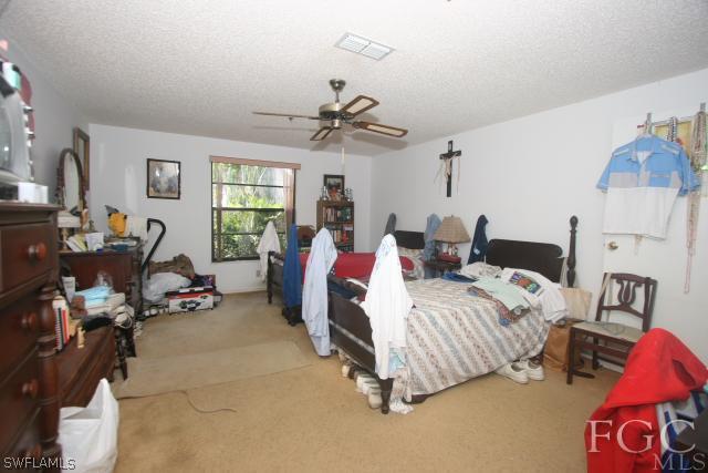 13901 Rod And Gun Club Road Fort Myers, FL 33913 - Photo 24 of 25 a spacious bedroom with two beds and a chandelier
