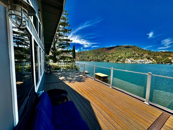 a balcony with wooden floor table and chairs