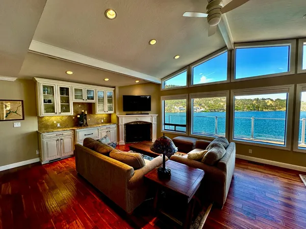 a kitchen with stainless steel appliances granite countertop a stove and a view of living room