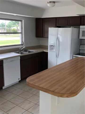 a view of an empty room with wooden floor and windows
