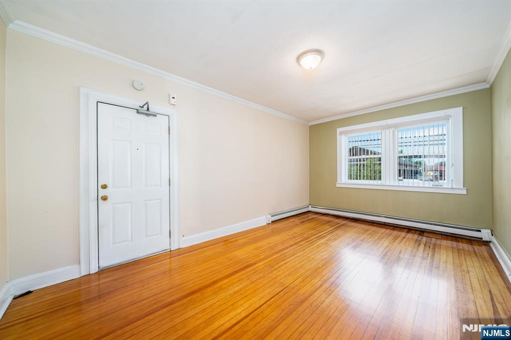 82 Hackensack Street, Unit 3 Wood-Ridge, NJ 07075 - Photo 5 of 19 a view of an empty room with wooden floor and a window