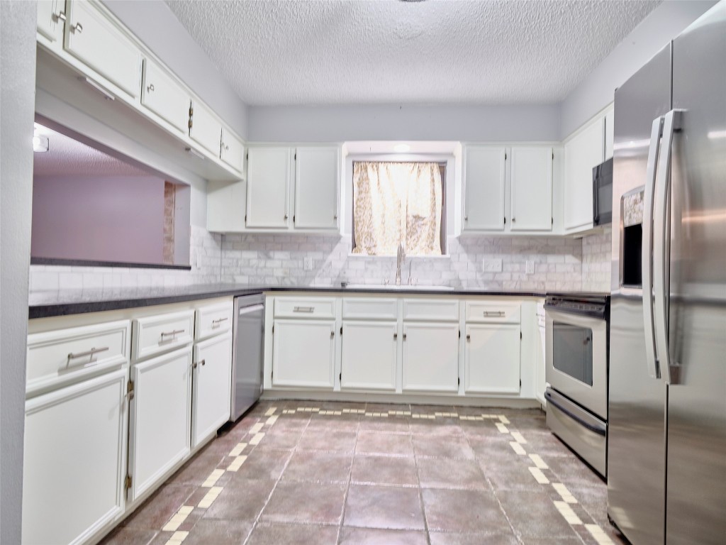 1520 Crestmont Street Wharton, TX 77488 - Photo 11 of 38 a kitchen with granite countertop a sink stainless steel appliances and cabinets