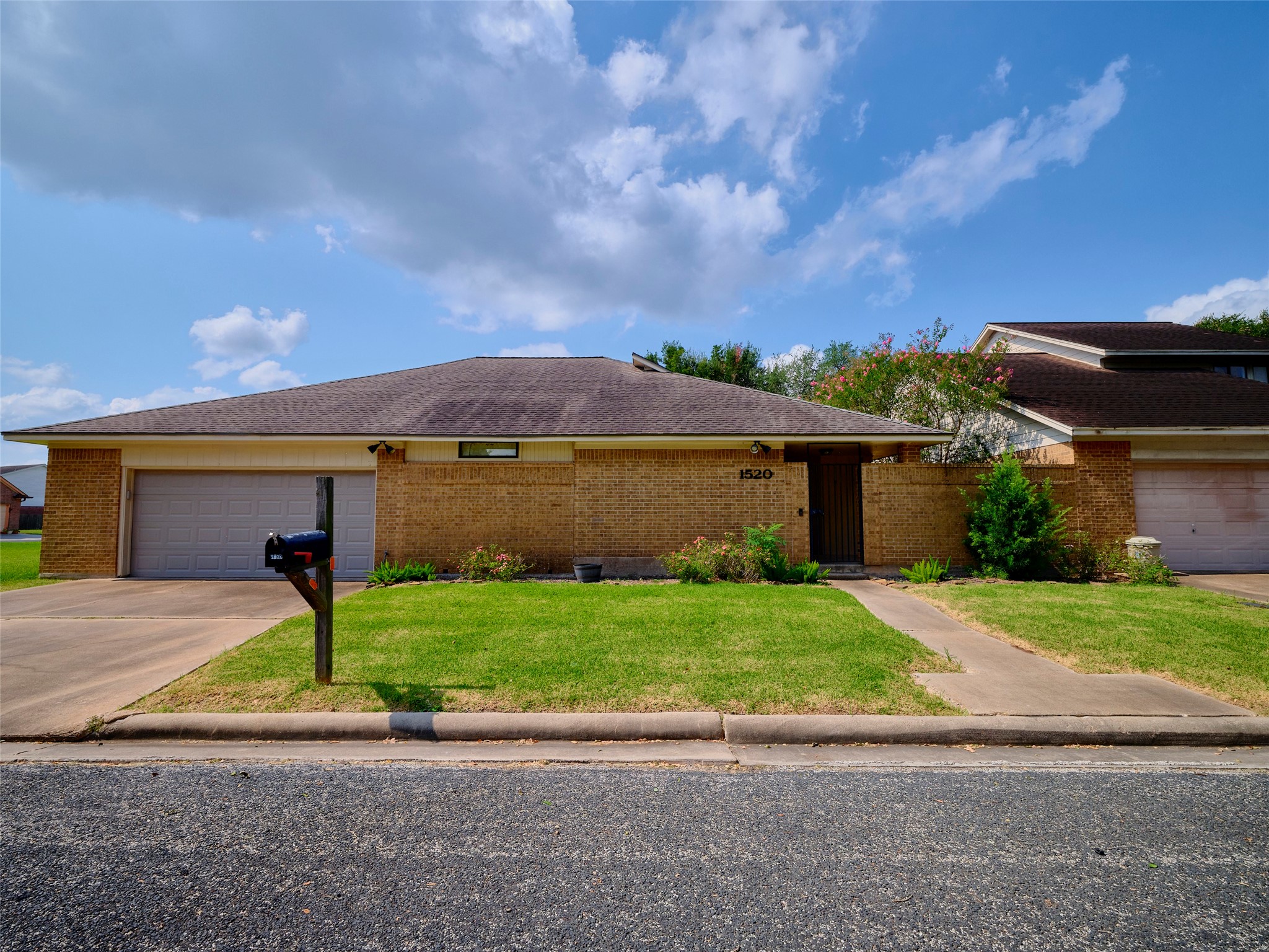 1520 Crestmont Street Wharton, TX 77488 - Photo 2 of 38 a front view of a house with a yard and garage