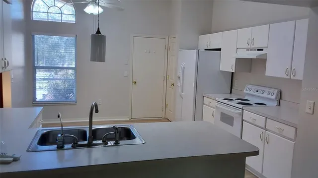 an empty room with windows and ceiling fan