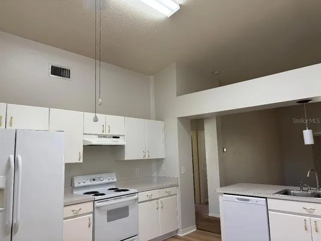 a kitchen with stainless steel appliances granite countertop a sink a stove and a refrigerator