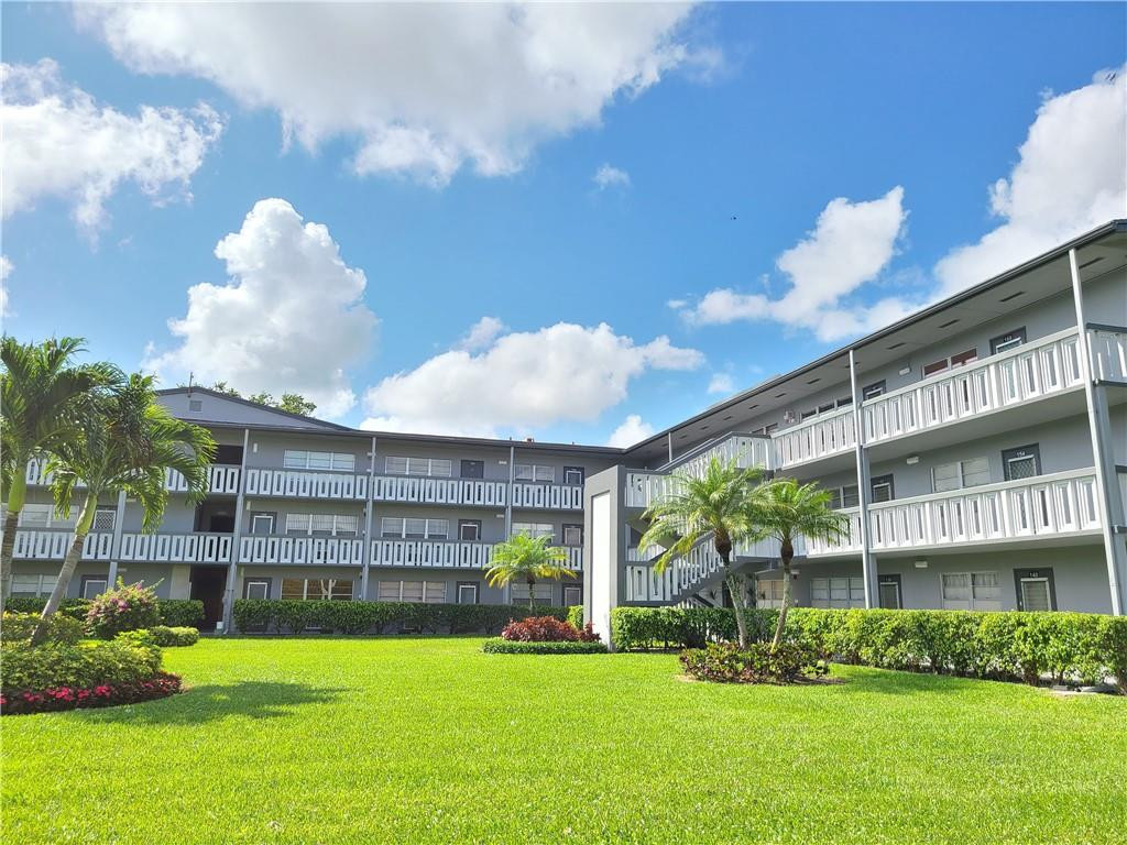 163 Suffolk F, Unit 163 Boca Raton, FL 33434 - Photo 1 of 34 a front view of a building with garden