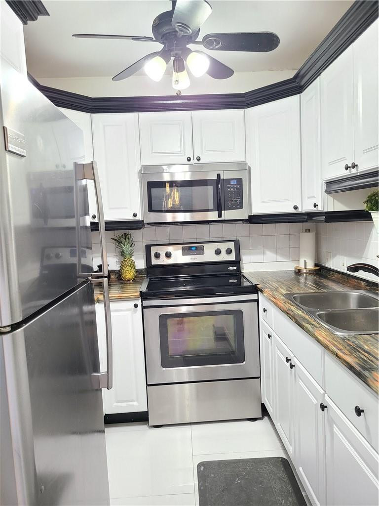 163 Suffolk F, Unit 163 Boca Raton, FL 33434 - Photo 11 of 34 a kitchen with stainless steel appliances granite countertop a stove a microwave and a refrigerator