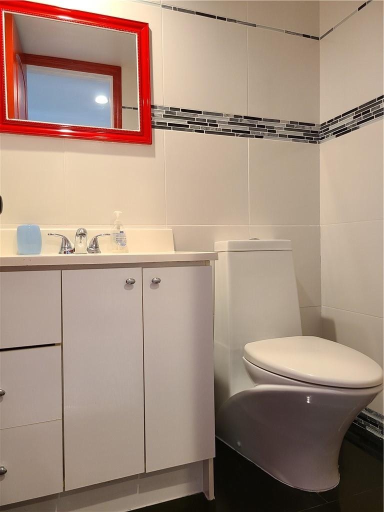 163 Suffolk F, Unit 163 Boca Raton, FL 33434 - Photo 19 of 34 a bathroom with a toilet sink and vanity