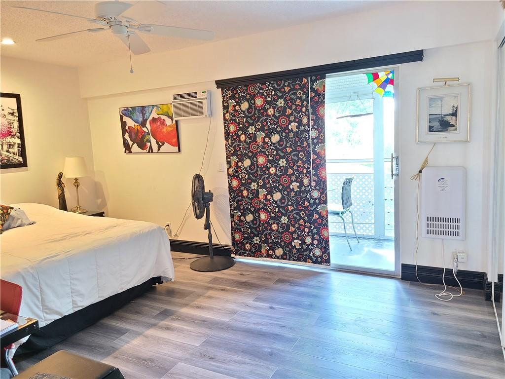 163 Suffolk F, Unit 163 Boca Raton, FL 33434 - Photo 20 of 34 a bedroom with a large bed and a chandelier