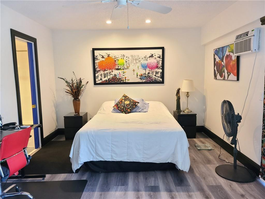 163 Suffolk F, Unit 163 Boca Raton, FL 33434 - Photo 21 of 34 a bedroom with a bed and a flat screen tv