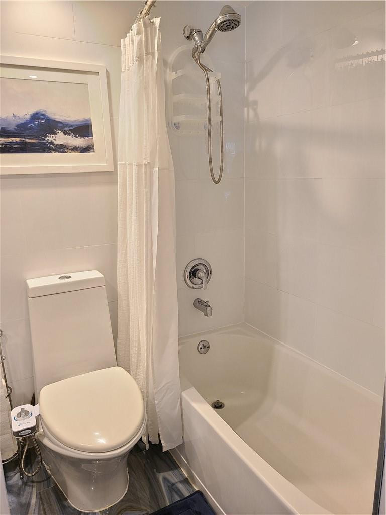163 Suffolk F, Unit 163 Boca Raton, FL 33434 - Photo 26 of 34 a white toilet sitting next to a bath tub and a shower