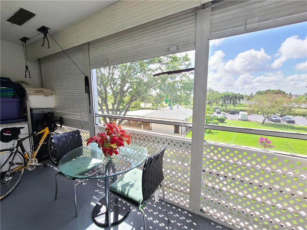 163 Suffolk F, Unit 163 Boca Raton, FL 33434 - Photo 29 of 34 a living room filled with furniture and a floor to ceiling window