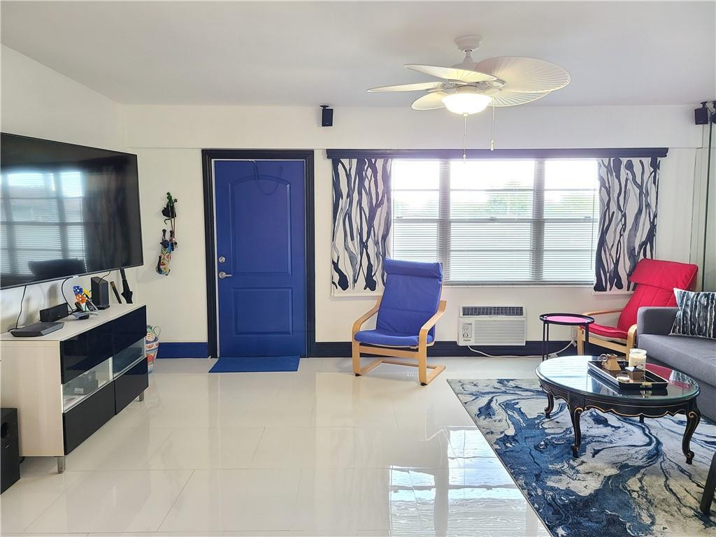 163 Suffolk F, Unit 163 Boca Raton, FL 33434 - Photo 4 of 34 a living room with furniture a chandelier and a window