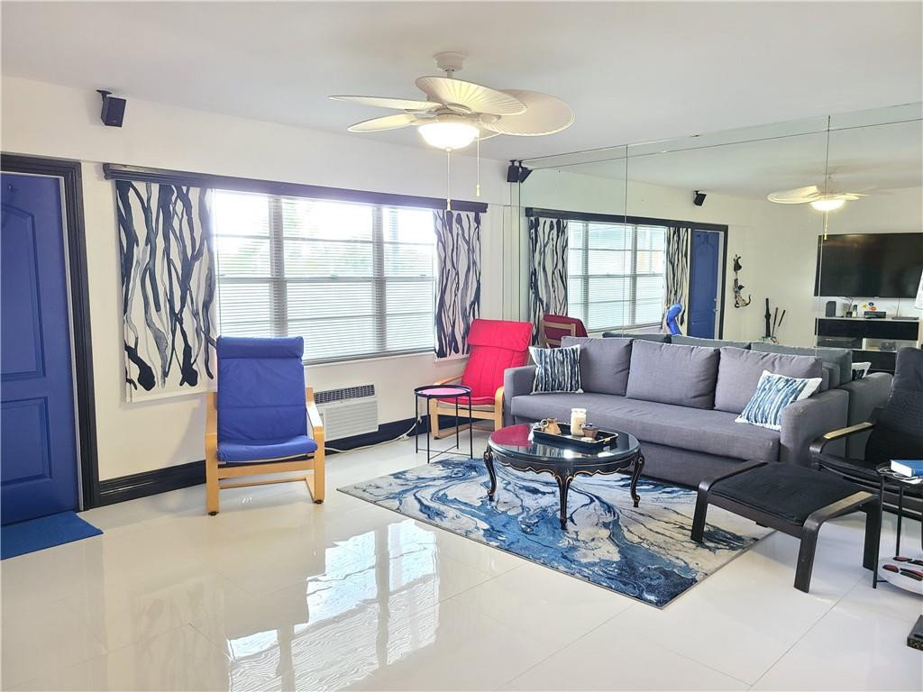 163 Suffolk F, Unit 163 Boca Raton, FL 33434 - Photo 5 of 34 a living room with furniture a flat screen tv and a large window