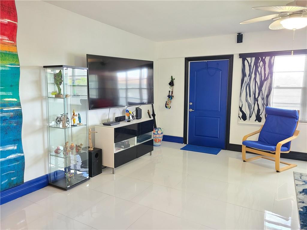 163 Suffolk F, Unit 163 Boca Raton, FL 33434 - Photo 6 of 34 a living room with furniture gym equipment and a flat screen tv