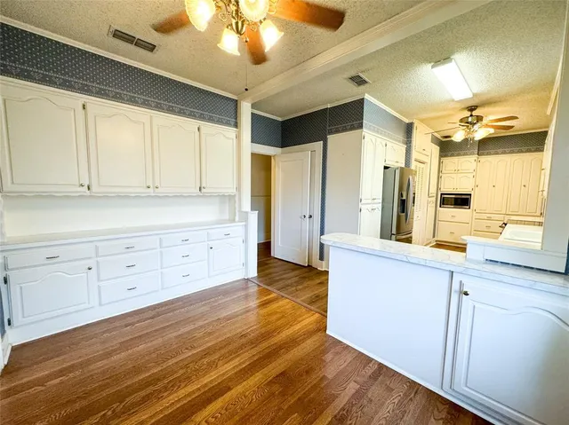 a large kitchen with cabinets and wooden floor