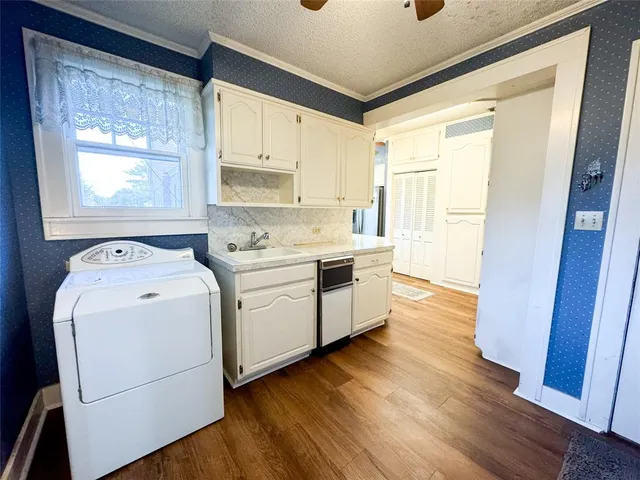 a view of a kitchen with wooden floor washer and dryer