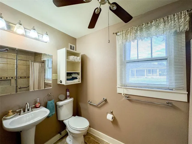 a bathroom with a toilet a sink and mirror