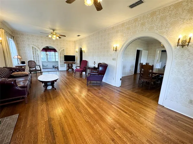 a living room with furniture and a wooden floor