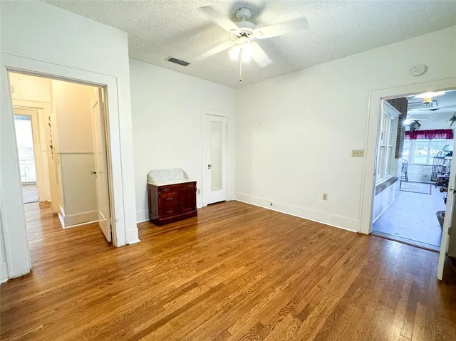 a view of a room with wooden floor and ceiling fan