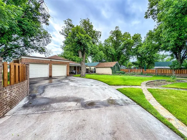 a front view of a house with a yard and trees