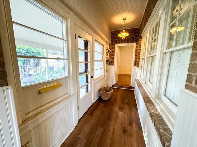 a view of a large mirror with wooden floor and windows
