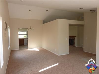 1539 Kings Road Palmdale, CA 93551 - Photo 3 of 22 a view of an empty room with a window and a kitchen