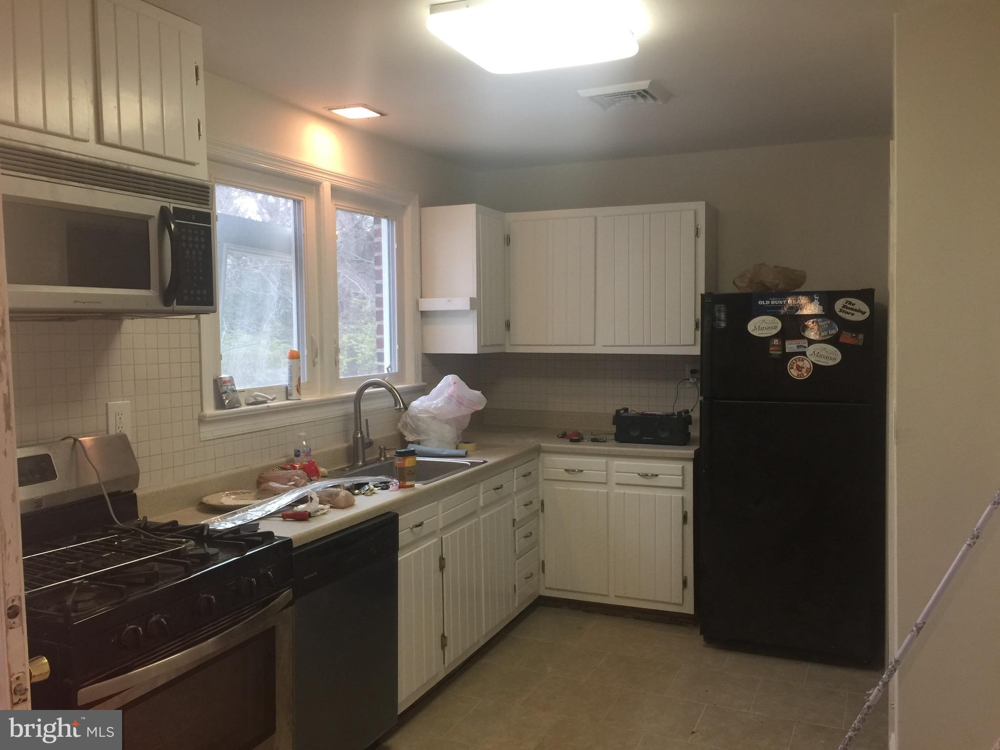 9101 Sudley Road Manassas, VA 20110 - Photo 12 of 16 a kitchen with a sink stove and refrigerator