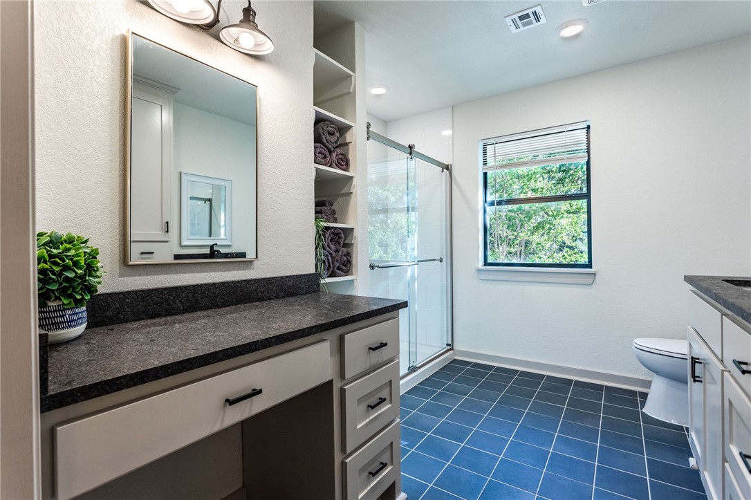 107 Spring Creek Street Waco, TX 76705 - Photo 47 of 78 a bathroom with a granite countertop sink a toilet a mirror and window