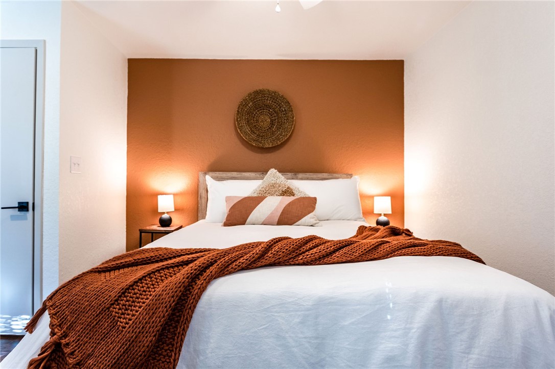 107 Spring Creek Street Waco, TX 76705 - Photo 58 of 78 a bedroom with a bed and a lamp on dresser