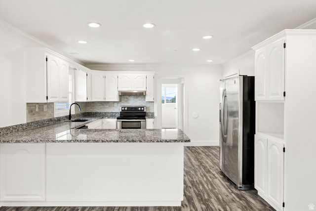 4155 Johnson Road Nibley, UT 84321 - Photo 13 of 71 Kitchen with a peninsula, stainless steel appliances, white cabinets, dark wood-style flooring, and dark stone counters