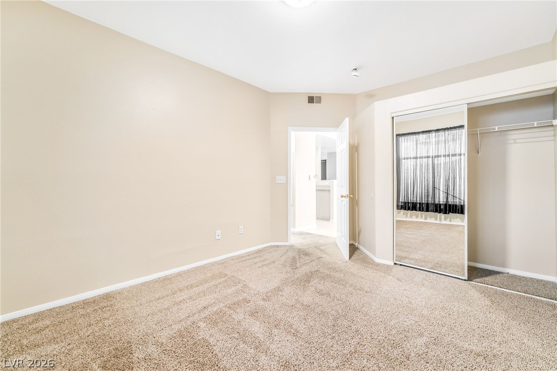2050 West Warm Springs Road, Unit 2411 Henderson, NV 89014 - Photo 25 of 37 Ample space for relaxation with soft carpeting, closet with mirrored doors, and gentle ceiling illumination.