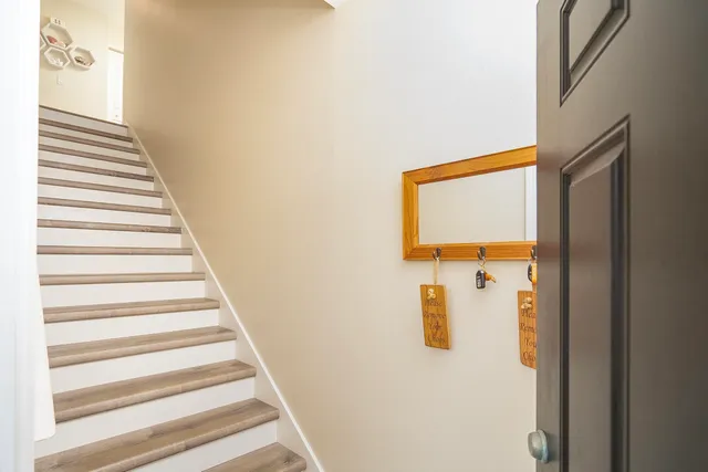 a open kitchen with stainless steel appliances granite countertop a stove top oven a sink a dining table and chairs with wooden floor