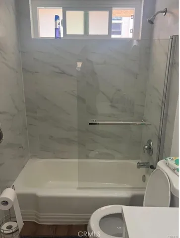 a bathroom with a toilet and a bath tub
