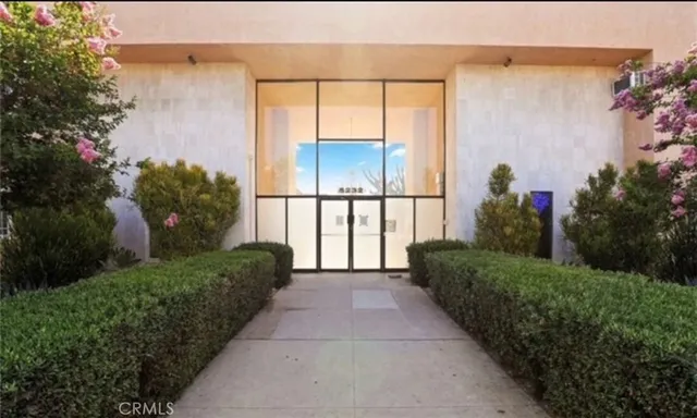 a front view of a house with a yard and potted plants