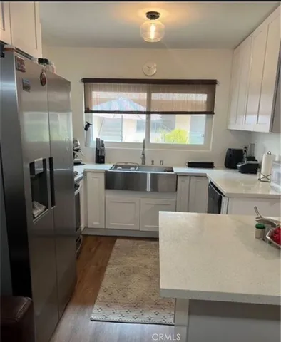 a kitchen with stainless steel appliances granite countertop a sink and a refrigerator