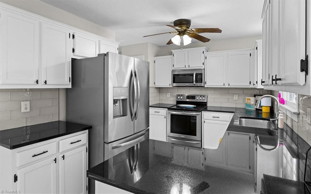 3329 Cardinal Ridge Drive Greensboro, NC 27410 - Photo 12 of 45 The kitchen has freshly painted cabinets and some recent updates to the appliances.