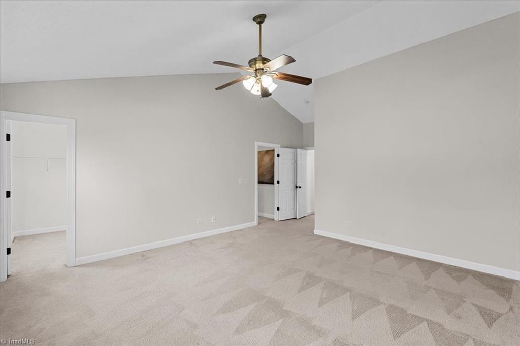 3329 Cardinal Ridge Drive Greensboro, NC 27410 - Photo 25 of 45 The primary suite with vaulted ceilings has two Large closets and an en-suite bathroom.