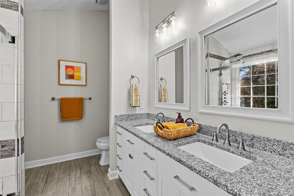 3329 Cardinal Ridge Drive Greensboro, NC 27410 - Photo 27 of 45 Updated primary bathroom has double sinks, solid countertops and an amazing walk in shower for 2!