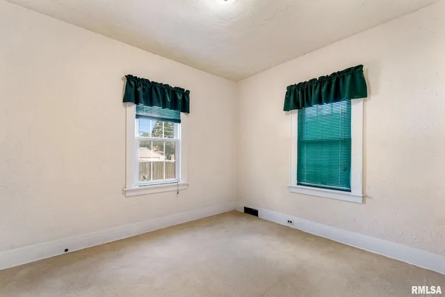 an empty room with windows and closet