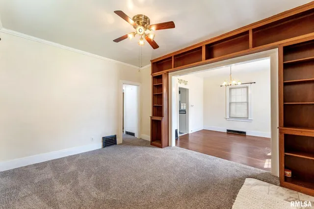 an empty room with closet and windows