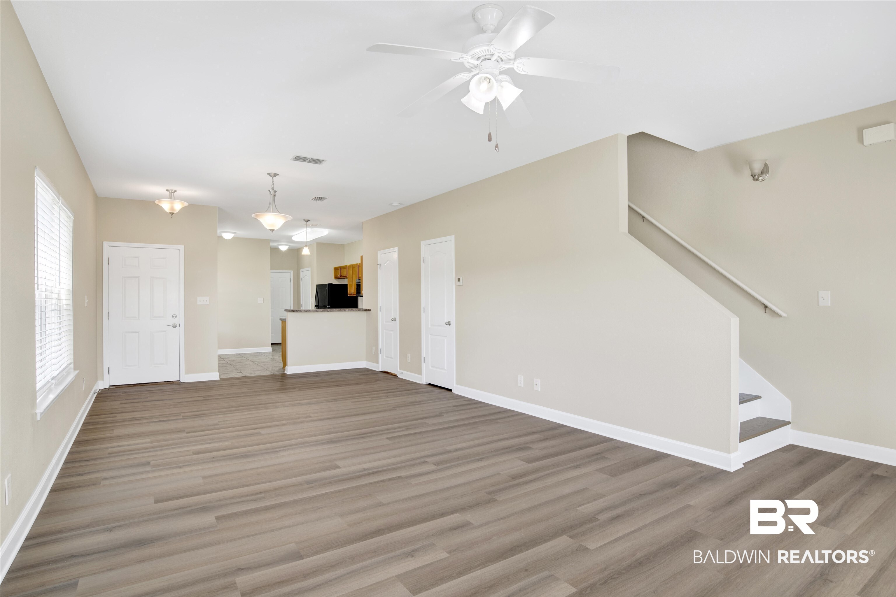 2002 Shelene Way Foley, AL 36535 - Photo 4 of 23 Unfurnished living room featuring light wood finished floors, stairway, and a ceiling fan