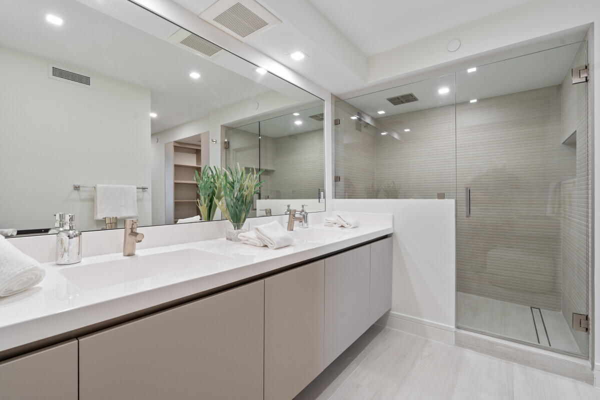 250 South Ocean Boulevard, Unit 11F Boca Raton, FL 33432 - Photo 11 of 45 a bathroom with a double vanity sink mirror and shower