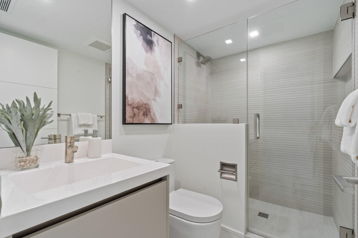250 South Ocean Boulevard, Unit 11F Boca Raton, FL 33432 - Photo 14 of 45 a bathroom with a sink a toilet and shower