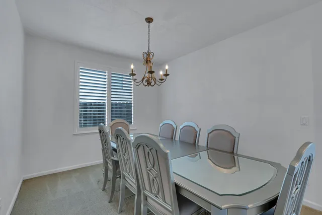 a view of a dining room with furniture and chandelier