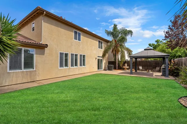 a view of a patio with a table and chairs under an umbrella with wooden fence