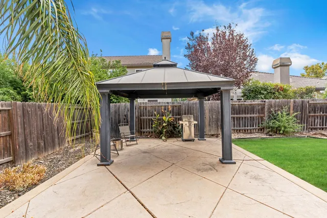 a view of a patio with a table and chairs under an umbrella